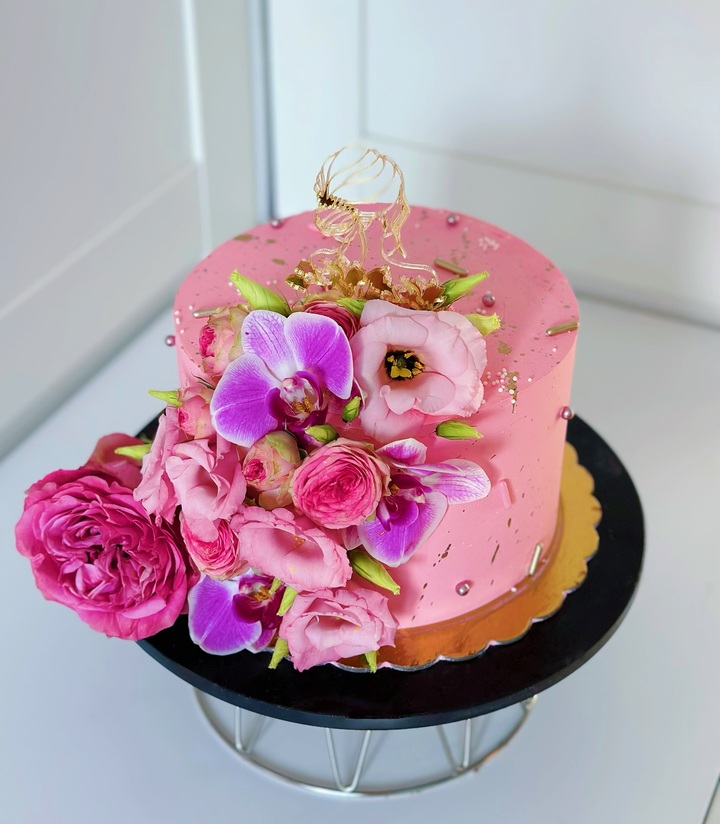 Na zdjęciu różowy tort z żywymi kwiatami - wykonany przez Słodkości dla gości